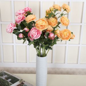 The hotel living room is decorated with flower arrangements featuring artificial